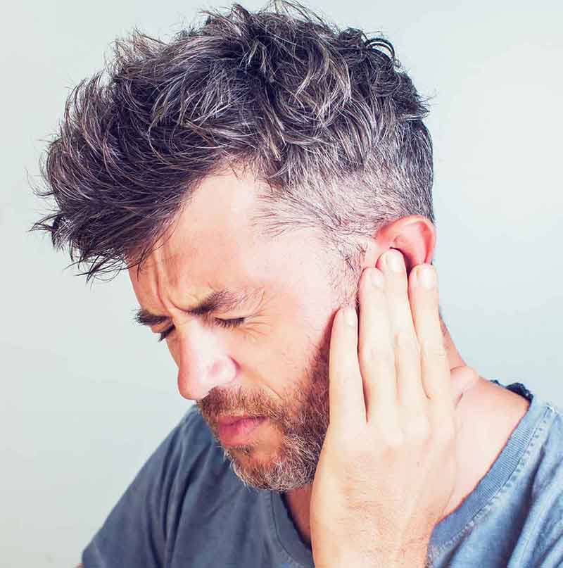 Man experiencing tinnitus (ringing in the ears)